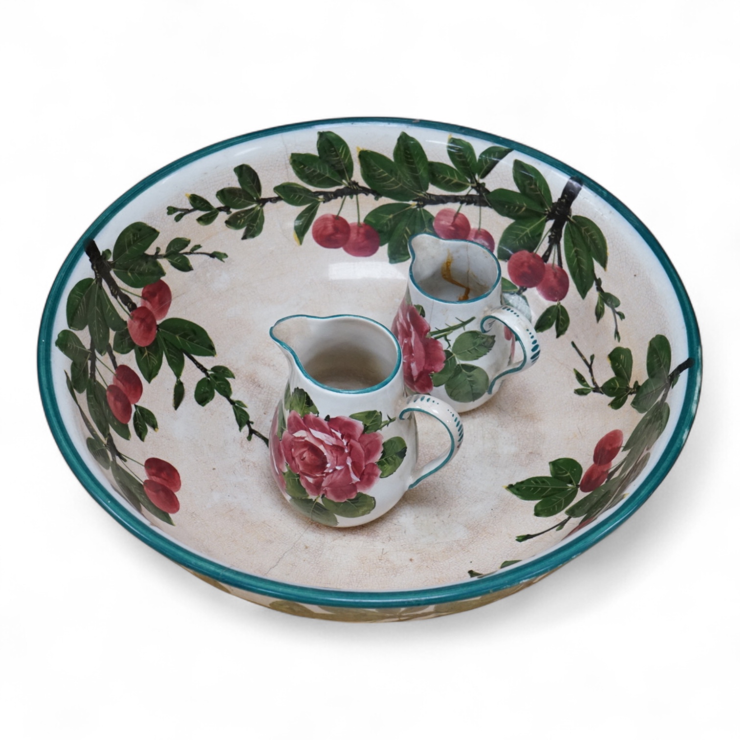 A Wemyss cherry branch decorated basin and two Wemyss jugs painted with cabbage roses, basin 38.5cm diameter. Condition- poor